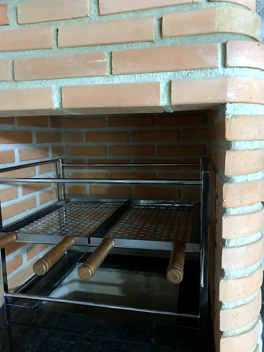 Churrasqueira de inox instalada em nicho de tijolo aparente